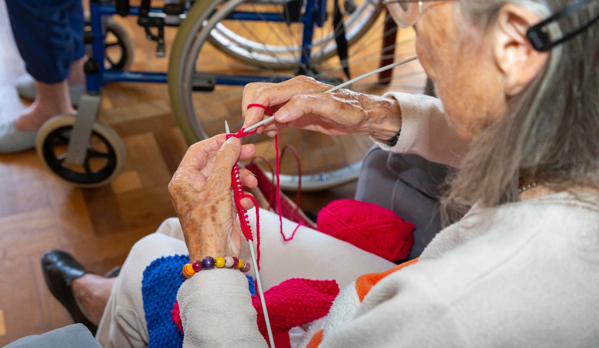 A resident knitting in the lounge at The British Retirement Home